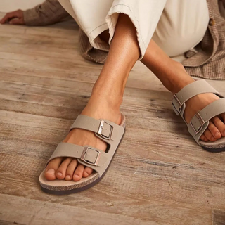 dame die beige sandalen draagt