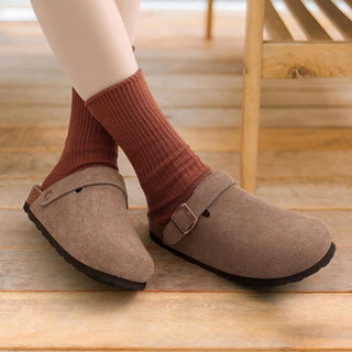 Dame draagt grijs bruine suède clog 