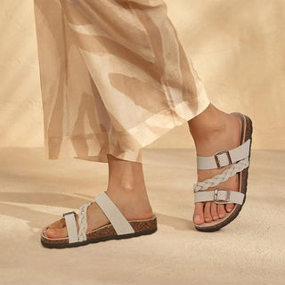 dame draagt beige sandaal met vlecht en kurken voetbed