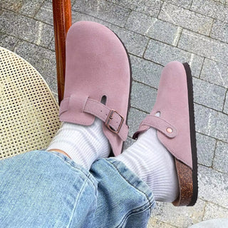 dame draagt suède roze clog met witte sokken